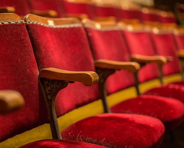 Old fashion cinema theatre seats with wooden arms flip-up seats