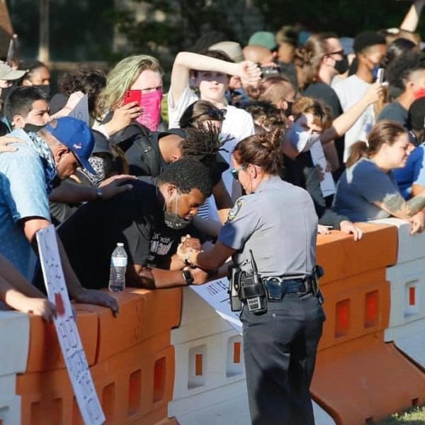 picture of OKC officer and a protester holding hands