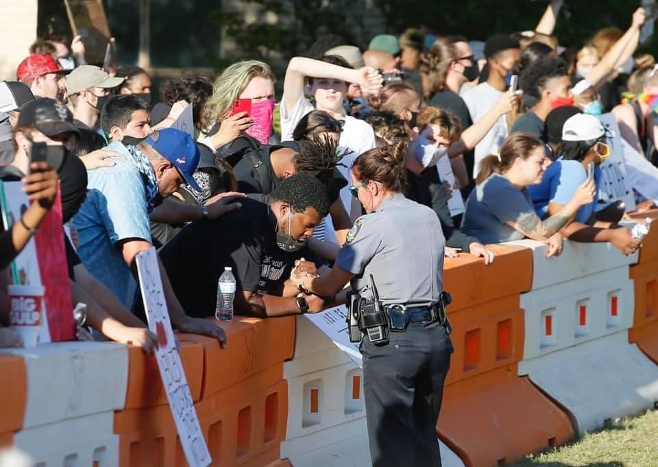 picture of OKC officer and a protester holding hands